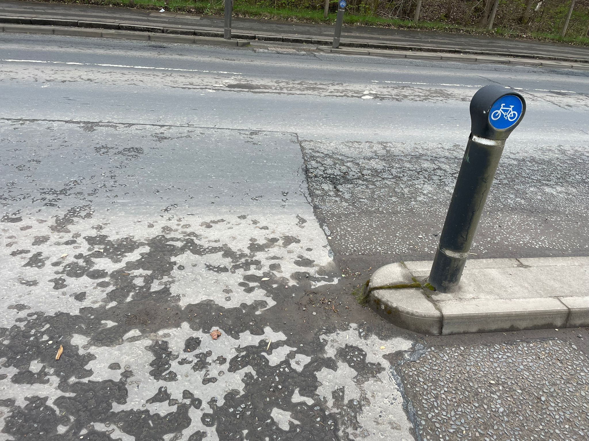 Cycle lane and degraded surface near bollard
